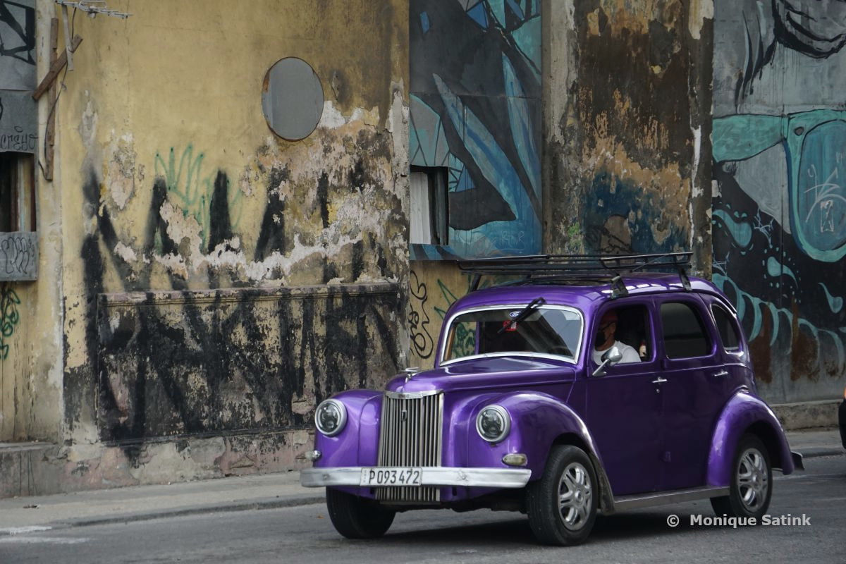 Auto met graffitimuur fietsvakantie Havana Cuba